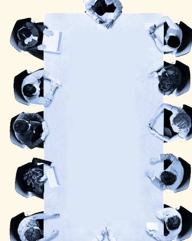 A team meeting around a long table, seen from above